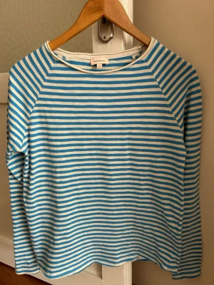 Randig långärmad topp Katestorm - Säljer en långärmad topp från Katestorm i storlek S. Toppen har smala blå och vita ränder, rund halsringning och är gjord i mjuk bomull. Perfekt för en avslappnad och stilren look.  Axelbredd 40cm, Längd 70cm