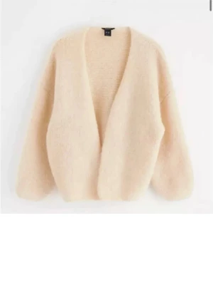 Lindex slutsåld - Supermjuk och fluffig beige kofta från & Other Stories. Koftan har en öppen design utan knappar, lång ärm och oversized passform. Perfekt att slänga på sig för en chill look. Tillverkad i ett mysigt stickat material.