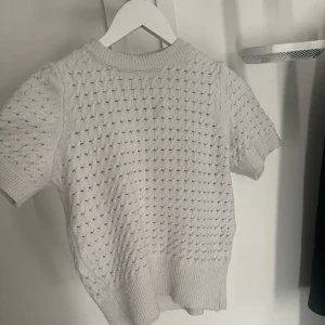 Vit stickad tshirt - Jättefin tröja från missäy. Den är inte kritvit, lite lite ljusgrå. Den har ett litet hål vid axeln men inget man tänker på. 