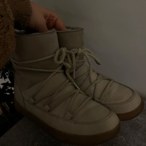 Beige boots med snörning - Säljer ett par snygga beige boots. De har en cool snörning som ger dem en unik look och en bekväm passform. Perfekta för höst och vinter, och de är gjorda i ett slitstarkt material som håller fötterna varma. Passar både till vardags och lite mer uppklädda tillfällen.