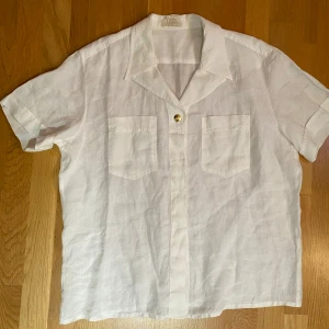 Vit blus i linne i strl 44 från Escada - Vit blus i linne i strl 44 från Escada.  Endast använd vid ett par tillfällen och är i väldigt fint begagnat skick.  Mått Över bröstet: ca 67 cm Längd från axeln och ner: ca 73 cm  100% linne  Kommer från ett djur och rökfritt hem.