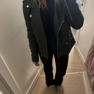 Svart skinnjacka från AllSaints - Säljer en snygg svart skinnjacka från Mango. Jackan är perfekt för höst och vår, och ger en fin look till vilken outfit som helst. En skinnjacka går liksom aldrig fel! Passformen är normal och den är långärmad.