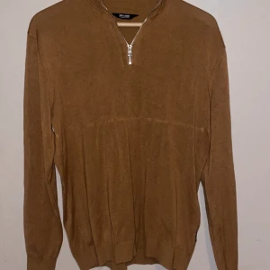 Half zip stickad tröja i brun/orange färg  - • Storlek - L/XL • Färg - Brun/orange • Tillverkning - Stickad • Tvättas i max 30 grader Har en liten fläck som syns på bild 2 (fläcken är ej synlig överlag) • Har inga andra förstörelser Använd i ett år • Märke - Only & Sons    
