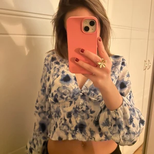 NY Blommig blus - Hm storlek S - Säljer en superfin blommig blus från hm! Blusen är helt ny och oanvänd, med lappen kvar. Den är croppad och har långa ärmar med en v-ringad design. 