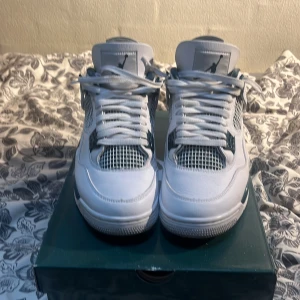 Nike Air Jordan 4 Retro - Säljer ett par Nike Air Jordan 4 Retro i vitt med snygga detaljer. Skorna har en klassisk design med snörning och en bekväm passform. Perfekta för både vardag och fest! De är i mycket bra skick och kommer i originalkartong. KÖPT I DUBAI MALL