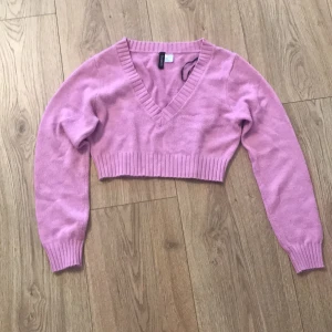 Rosa croppad tröja från H&M Divided - Säljer en superfin rosa croppad tröja från H&M Divided. Den har en snygg v-ringning och långa ärmar. Perfekt för vår och sommar! Tröjan är i mycket bra skick och gjord av mjukt material som känns skönt mot huden. Passar perfekt till både jeans och kjol! 🌸