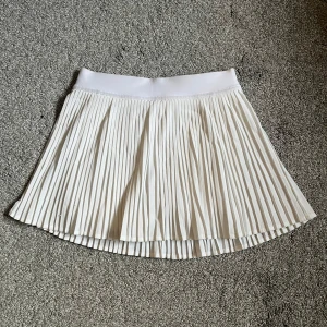 Vit plisserad kjol från Lululemon🧘🏼‍♀️🛁 - Säljer superfin vit plisserad kjol i nyskick från Lululemon i storlek 4 (liknar xs).❣️  Perfekt för träning eller bara i vardagen. Kjolen är gjord av polyester och elastan, vilket gör den både bekväm och stretchig. 🍵Den har en bred midjeresår för extra komfort.🎀Köpt för 800kr, använd 2 ggr. Skriv till mig vid frågor eller funderingar.💕