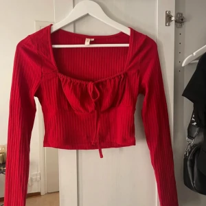 Röd topp - Långärmad, croppad topp ifrån Nelly. Rött ribbat material med en ett knyte/rosett i fram❤️ Endast provad på, aldrig använd