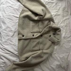 Croppad ”Teddy jacka” från H&M i storlek M, beige färg. Köpt för 300 kr men säljer nu för 150 kr. Har bara använts två gånger. Köparen står för frakten 