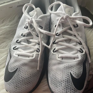  Nike sneakers - Säljer ett par snygga vita och svarta Nike sneakers i nyskick. Perfekta för både träning och vardagsbruk. Skorna är i strl 39. Sparsamt använda.