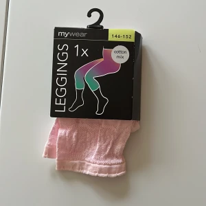 Rosa leggings från MyWear - Säljer ett par supermjuka rosa leggings från MyWear i storlek 146-152. De är gjorda av en skön bomullsblandning som passar perfekt för vardagsbruk. Leggingsen har ett diskret mönster och är stretchiga för bästa komfort. Perfekta för både skola och fritid! Oöppnade. Djur och rökfritt hem. 