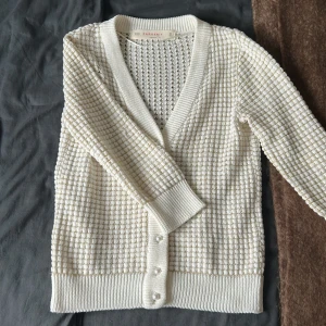 Vit stickad kofta från Zaraknit - Säljer en Zara stickad kofta tre kvarts armar. Tröja är i bra skick förutom attt trådarna på bild 3 har gått upp lite. 