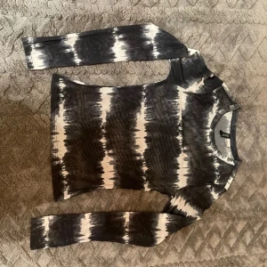 Meshtopp från H&M - Snygg genomskinlig långärmad topp från Divided i svart och vitt med ett coolt batikmönster. Toppen har en tight passform och är tillverkad i ett mjukt material. Passar S