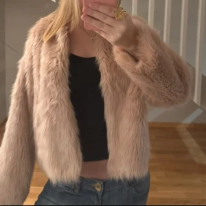 Beige pälsjacka - Säljer en snygg beige pälsjacka med långärmad design. Den är mjuk och bekväm, idealisk för kyligare dagar.
