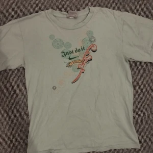 Ljusgrön t-shirt från Nike - Säljer en ljusgrön t-shirt från Nike med trycket 'Just do it' i en kreativ design. T-shirten är tillverkad i 100% bomull och har korta ärmar. Perfekt för en avslappnad stil.