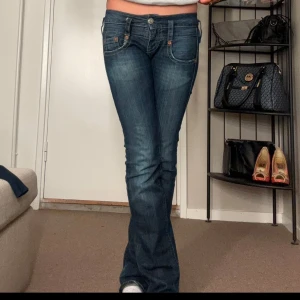 Blå bootcut jeans - Snygga blå bootcut jeans med låg midja. Midje måttet rakt över är 38 cm och inerben lengden är 80