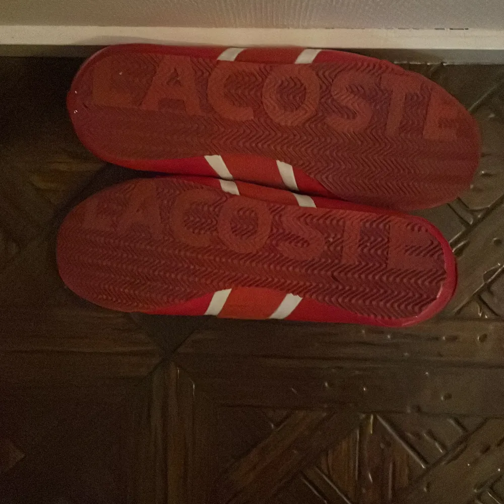 Snygga röda sneakers från Lacoste med vita detaljer och snörning. Skorna har en sportig design med Lacoste-logga på sidan och mönstrad sula för bra grepp. Perfekta för en casual look. Kontakta mig för minsta lilla fundering pris kan diskuteras OBS Har inte kvitto eller box för skorna är köpta för länge sedan. Kengät.