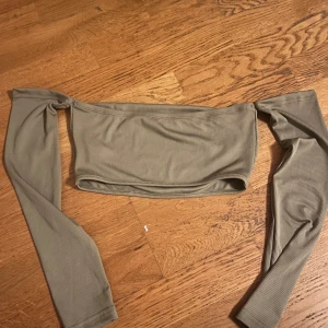 Grå ribbad offshoulder topp - Snygg grå ribbad offshoulder topp med långa ärmar. Perfekt för en stilren och trendig look. Passar bra till både jeans och kjol.