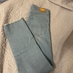 Ljusblå jeans från Denizen by Levi's - Snygga ljusblå jeans från Denizen by Levi's med hög midja och rak passform. Perfekta för en avslappnad stil. Klassisk femficksdesign och knappgylf.