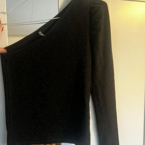 Svart glittrig topp  - En jättefin one-shoulder topp i svart glitter, bara använd 1 gång💕