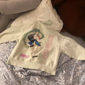 Beige tröja med Hatsune Miku-tryck - Säljer en beige tröja med ett stort tryck av Hatsune Miku på framsidan. Säljer då den inte kommer till användning. 