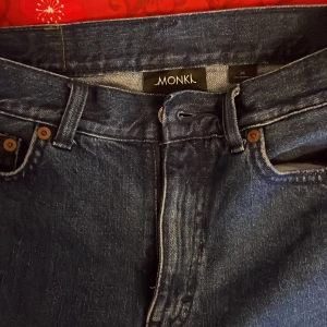 Blå jeansshorts från Monki - Snygga blå jeansshorts från Monki med fransiga kanter och klassisk femficksdesign. Perfekta för en avslappnad sommarlook. De har en dragkedja och knapp framtill.