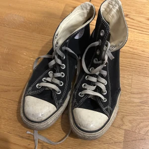 Svarta Converse All Star sneakers - Klassiska svarta Converse All Star sneakers med snörning och vit tåhätta. Perfekta för en avslappnad stil. Riktigt slitna därav priset, kolla bilder, man får vad man betalar för 😊👍