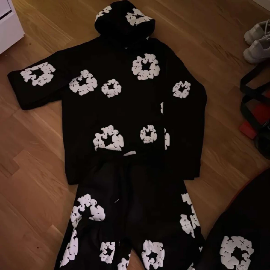 Svart hoodie och byxor med vita blommor från denim tears