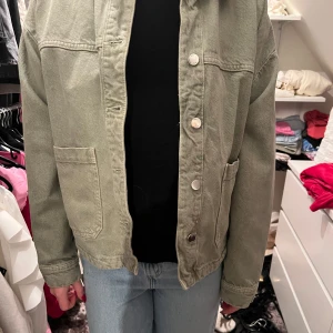 Grön jacka från Zara - Säljer en snygg grön jacka från Zara. Jackan har en avslappnad passform med knappar framtill och stora fickor. Perfekt för en casual look.