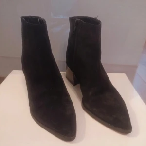 Clou ankle boots .  - Clou ankle boots . Snygga  ankle boots från Clou, i perfekt skick, endast använda en gång. Snygga svarta boots i mocka med spetsig tå och dragkedja på sidan. De har en stabil klack som ger extra höjd och stil. Perfekta för en trendig look.