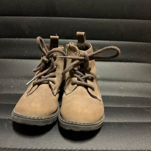 Bruna kängor med snörning - Säljer ett par bruna kängor i mocka med snörning. De har en robust sula och är perfekta för höst och vinter. Storlek 23. Från H&M