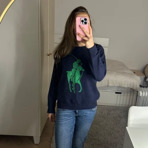 Mörkblå tröja - Säljer en mörkblå Ralph lauren tröja med ett stort tryck på framsidan. Tröjan har långa ärmar och en rund halsringning. Väldigt skönt material. Säljer då jag inte använder längre. 