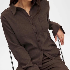 Brun skjorta med knappar - Snygg brun skjorta med krage och knappar framtill. Skjortan har en bröstficka och långa ärmar. Något strukturerad i materialet som man kan se på sista bilden. Storlek 34. Nypris :499kr🥰