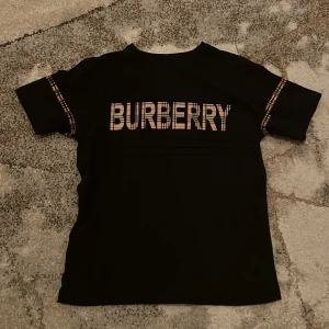 Burberry T-shirt - Snygg svart t-shirt från Burberry. Tröjan är väldigt stilig och använd max 3 gånger, köpte den från England