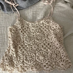Beige spetslinne från Stories - Säljer ett beiget spetslinne från Stories i storlek XS. Linnet har ett virkat mönster och smala axelband som knyts.💕
