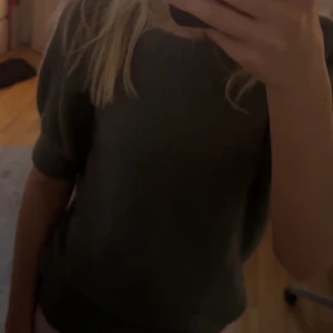 Grön tröja - Säljer en enkel och stilren grön tröja med korta ärmar. Perfekt för en avslappnad look.