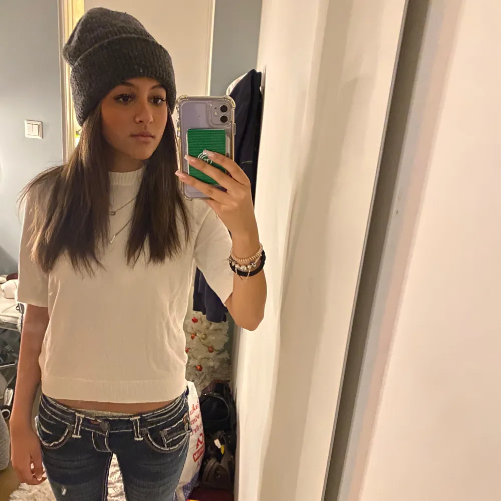 Säljer en stilren vit tröja med korta ärmar. Perfekt för en avslappnad look. Tröjan har en enkel design och är lätt att matcha med olika outfits.. Neuletakit & Villapaidat.