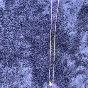Guldhalsband med ringdetalj - Elegant guldhalsband med en enkel ringdetalj som hänge. Perfekt för att lägga till en subtil touch av stil till din outfit. Gjord i rostfritt stål.