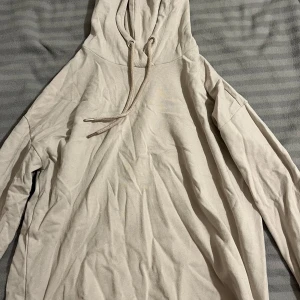 Beige hoodie från Etirel - Säljer en beige hoodie från Etirel i storlek S. Den har en klassisk design med dragsko i huvan och långa ärmar. Perfekt för en avslappnad stil.