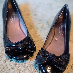 Svarta ballerinaskor i lack med söt rosett - Super söta svarta ballerinaskor från Dublin med en elegant rosett på tån. Fina att gå i till vardags och fest. Bara använd några få gånger.