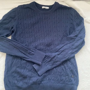 Marinblå kabelstickad tröja från J.Lindeberg - Fet kabelstickad tröja från J.Lindeberg. Storlek M men passar S också. Skriv för mer info eller bilder!