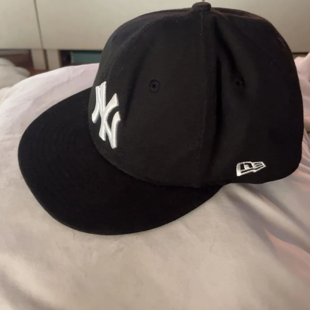 Snygg svart keps från New Era. Storlek: 58,7 cm. Mycket bra skick, knappt använd. Asusteet.