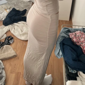 Beige långkjol - Snygg beige långkjol i ett mjukt och stretchigt material. Den är köpt från Gina och är i storlek xs, jag säljer den för 200kr!😊