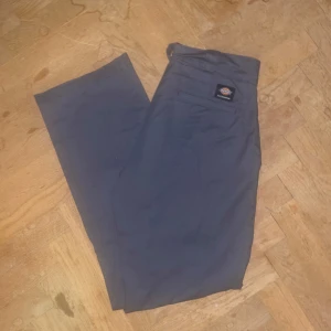 Grå byxor från Dickies - Säljer ett par grå byxor från Dickies Skateboarding-kollektion. Byxorna har en klassisk design med normal passform och midwaist. Perfekta för en avslappnad stil.