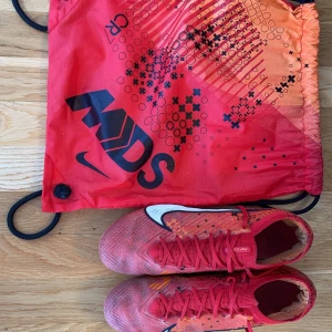 Nike fotbollsskor elite - Säljer ett par röda Nike fotbollsskor med snörning och vit Nike loga. Finns också boxen till den. Samt lite skador men inte så farligt. Bara seriösa köpare!!! Sänker priset vid snabb affär !!!!