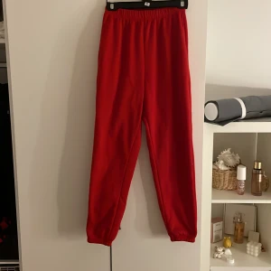 Röda mjukisbyxor - Säljer ett par bekväma röda mjukisbyxor med elastisk midja. Perfekta för en avslappnad dag hemma eller en promenad i parken. Byxorna har en enkel design och är gjorda i ett mjukt material.