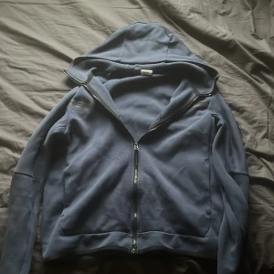 Nike tech - Säljer en blå huvtröja med dragkedja. Enkel och stilren design som passar till det mesta. Ny pris runt 1000kr pris kan förhandlas 