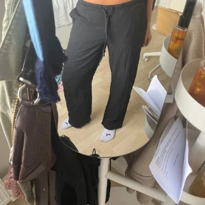 Linnebyxor - Säljer ett par svarta linne byxor från Gina Tricot i storlek XS. Byxorna har en avslappnad passform och är tillverkade i ett mjukt material. Perfekta för en bekväm stil.