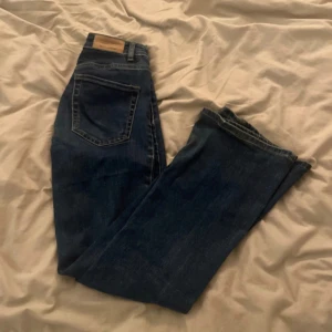 Mörkblå jeans från Stradivarius - Snygga mörkblå jeans från Stradivarius med klassisk femficksdesign och knappgylf. Perfekta för en avslappnad stil. De har en rak passform som ger en tidlös look.