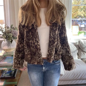 Brun pälsjacka - Säljer en snygg brun pälsjacka med leopardmönster. Jackan har långa ärmar och en mysig, fluffig känsla. Perfekt för att hålla sig varm och stilren under kyliga dagar. Pris kan diskuteras vid snabbaffär